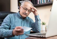 Person reviewing financial information on a laptop, illustrating fraud and money laundering investigations